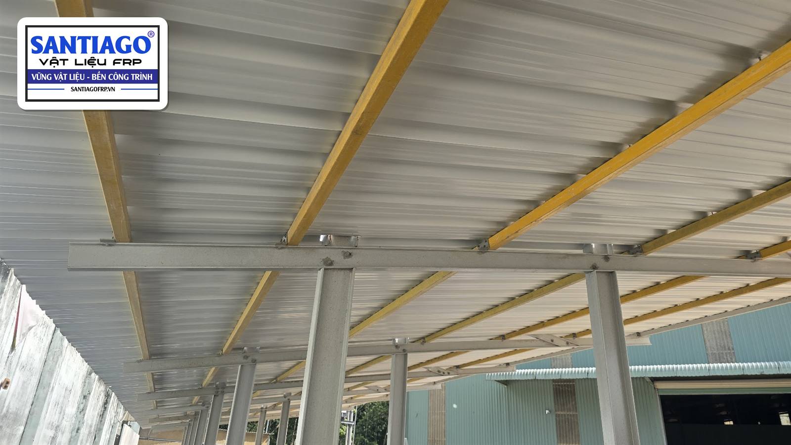 Xà gồ composite vàng dưới mái tôn cạnh nhà xưởng